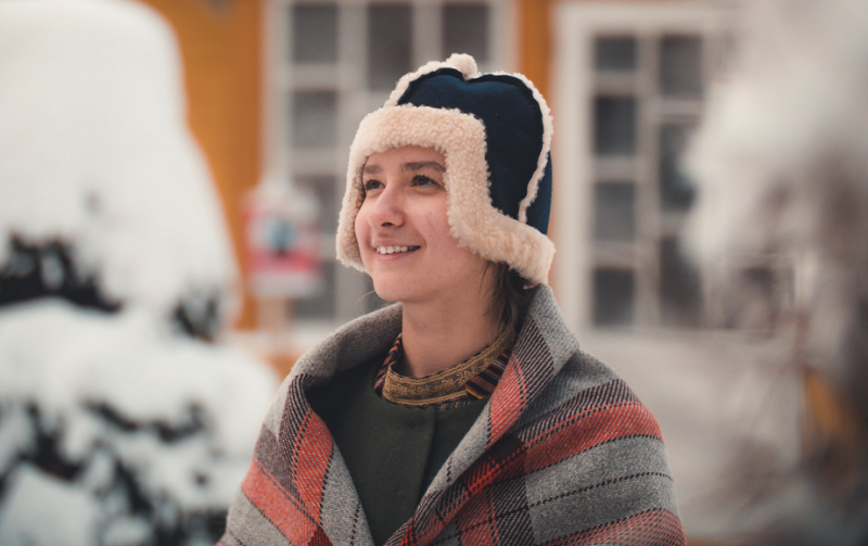  Meitene tautastērpā un ziemas cepurē.