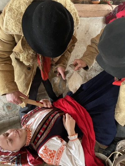 "Vēdera šūšana" ar lielu koka adatu (tradicionāls masku gājiena elements).