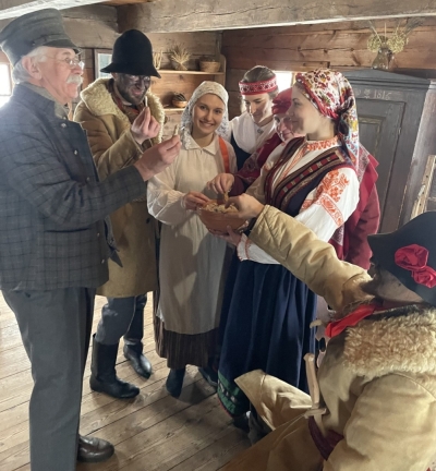 Dalībnieki cienājas ar ceptām zivīm no bļodas.