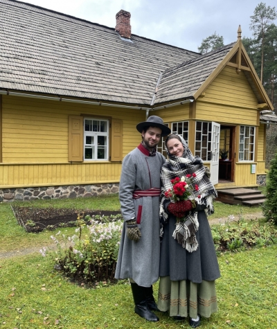 Jauniešu pāris tautastērpos pie muzeja Jaunsaimniecības ēkas.