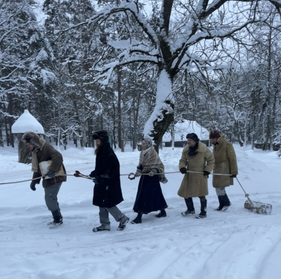Bluķa vilkšanas tradīcija: cilvēki velk koka bluķi. 