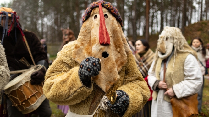 Mārtiņdienas  maskas; centrā tēls ar lielu, sarkanu degunu. 