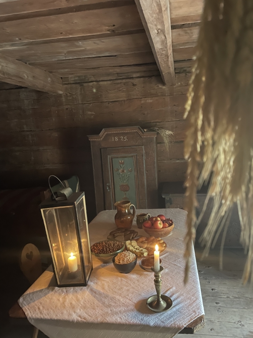 Tradicionāls veļu mielasts klētiņas iekštelpā, kur uz koka galda sagatavots cienasts senā, autentiskā vidē.