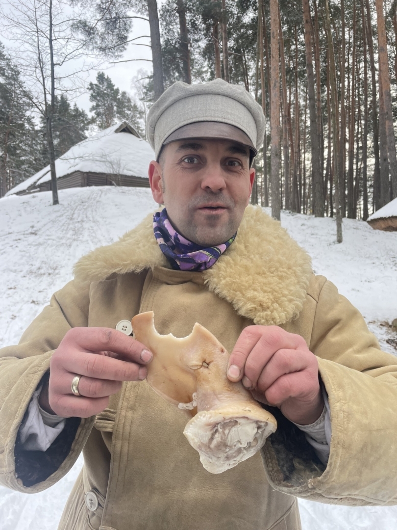 Puisis ar prieku rokās tur iekostu vārītu cūkas ausi