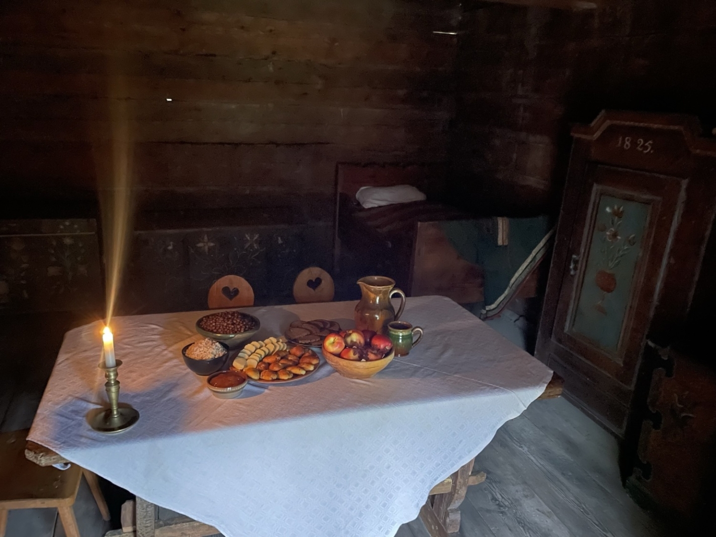 Vakarīga un mājīga noskaņa klētī, kur uz klāta galda līdzās tradicionālajam ēdienam deg svecīte veļu piemiņai.