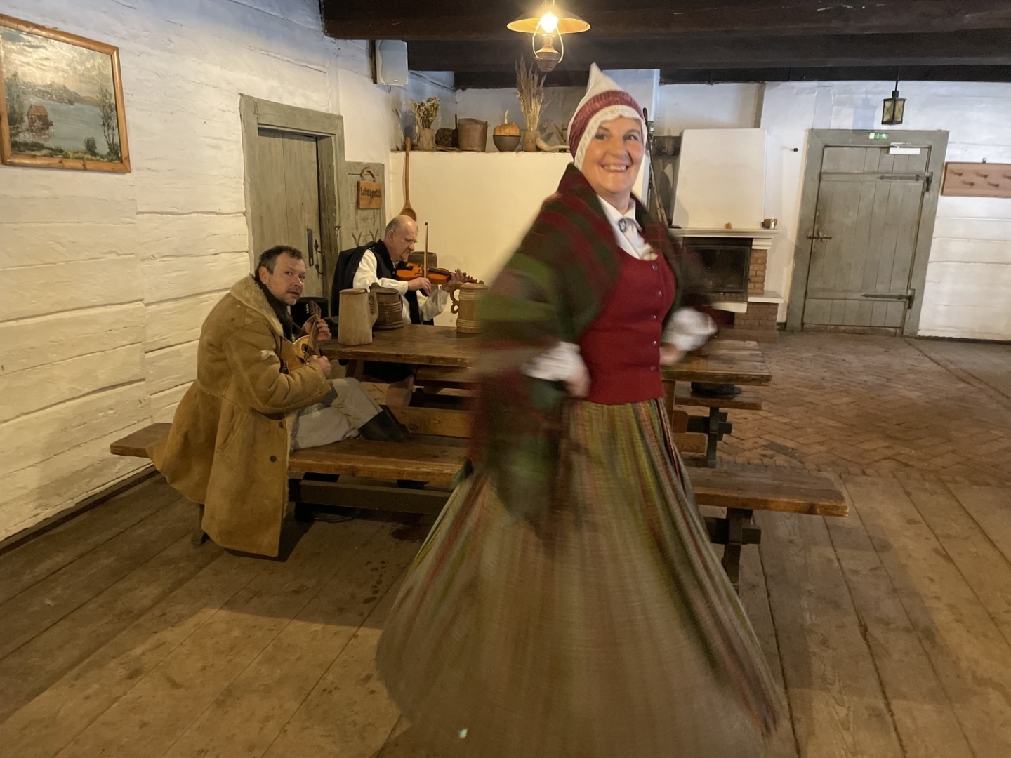Sieviete krāšņā latviešu tautastērpā iemūžināta dejas kustībā