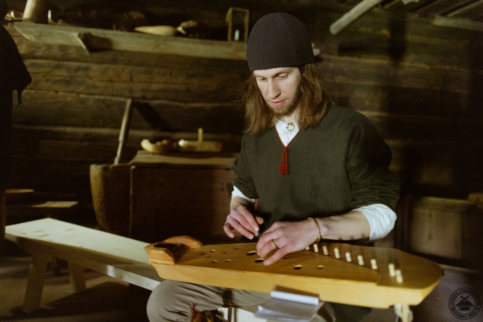 Jauns puisis tautastērpā koncentrējies spēlē tradicionālo stīgu instrumentu – kokli.