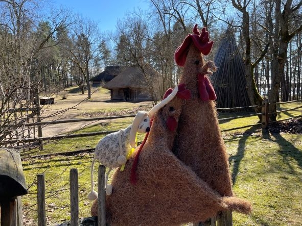 Lieldienu dekors Vidzemes sētā: stilizētas gaiļa, vistas un zaķa figūras.