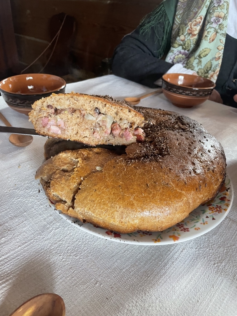 Sagriezts slokātnis, kurā redzama maizes un ceptas gaļas kārtu mija