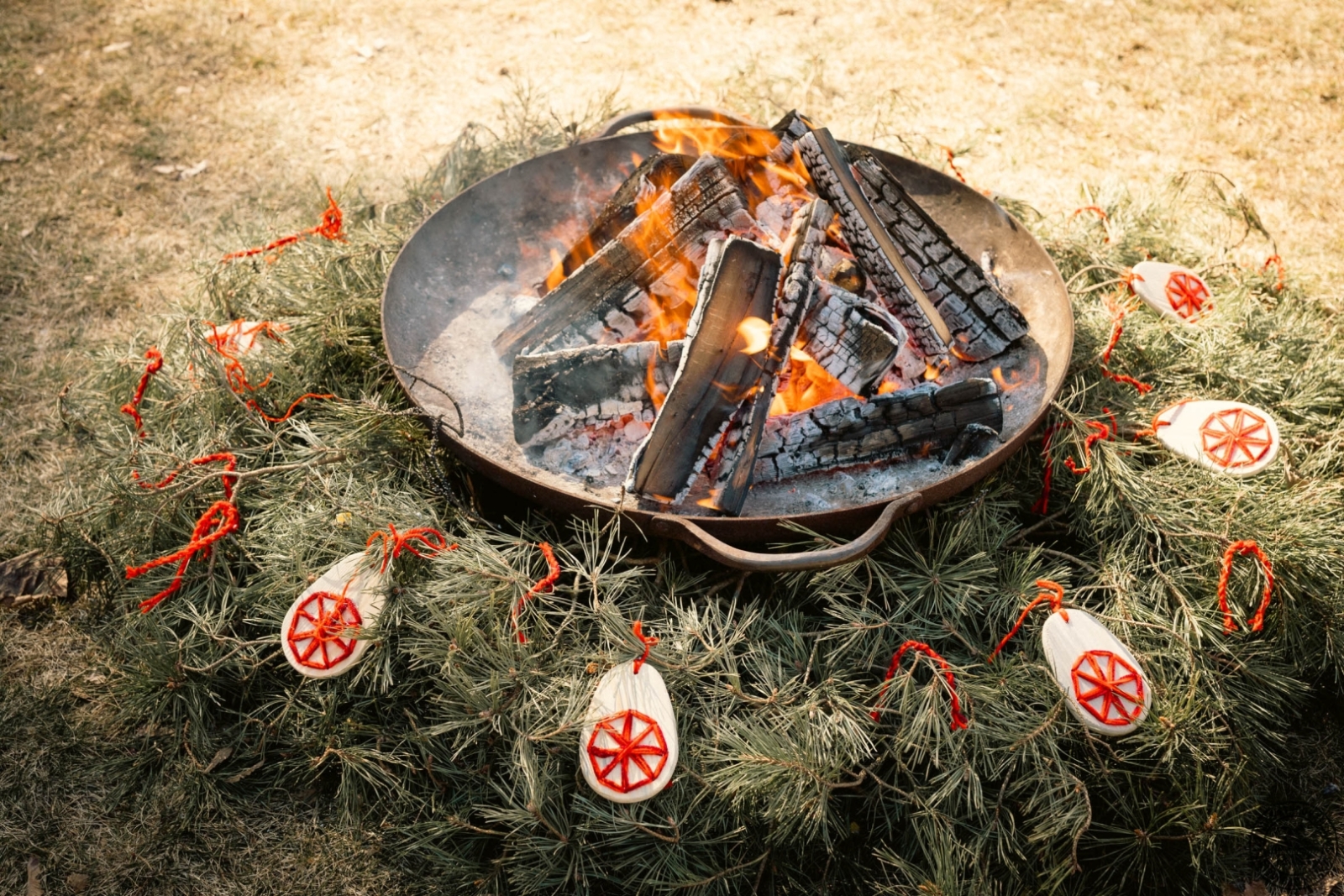 Lieldienu svinību ugunskurs, kas izrotāts ar dabas veltēm un sagatavots tradicionālajiem ziedojumiem.