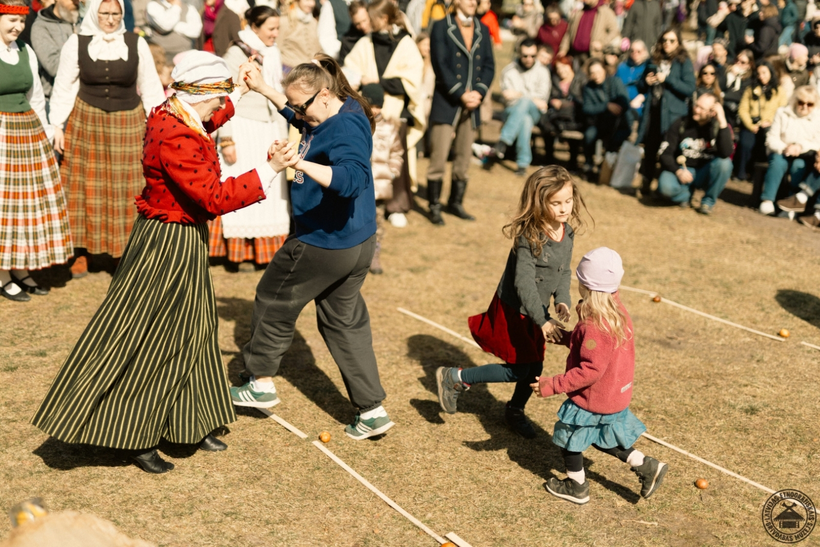 Pasākuma dalībnieki un folkloras kopa vienojas kopīgā Lieldienu dancī un rotaļās.