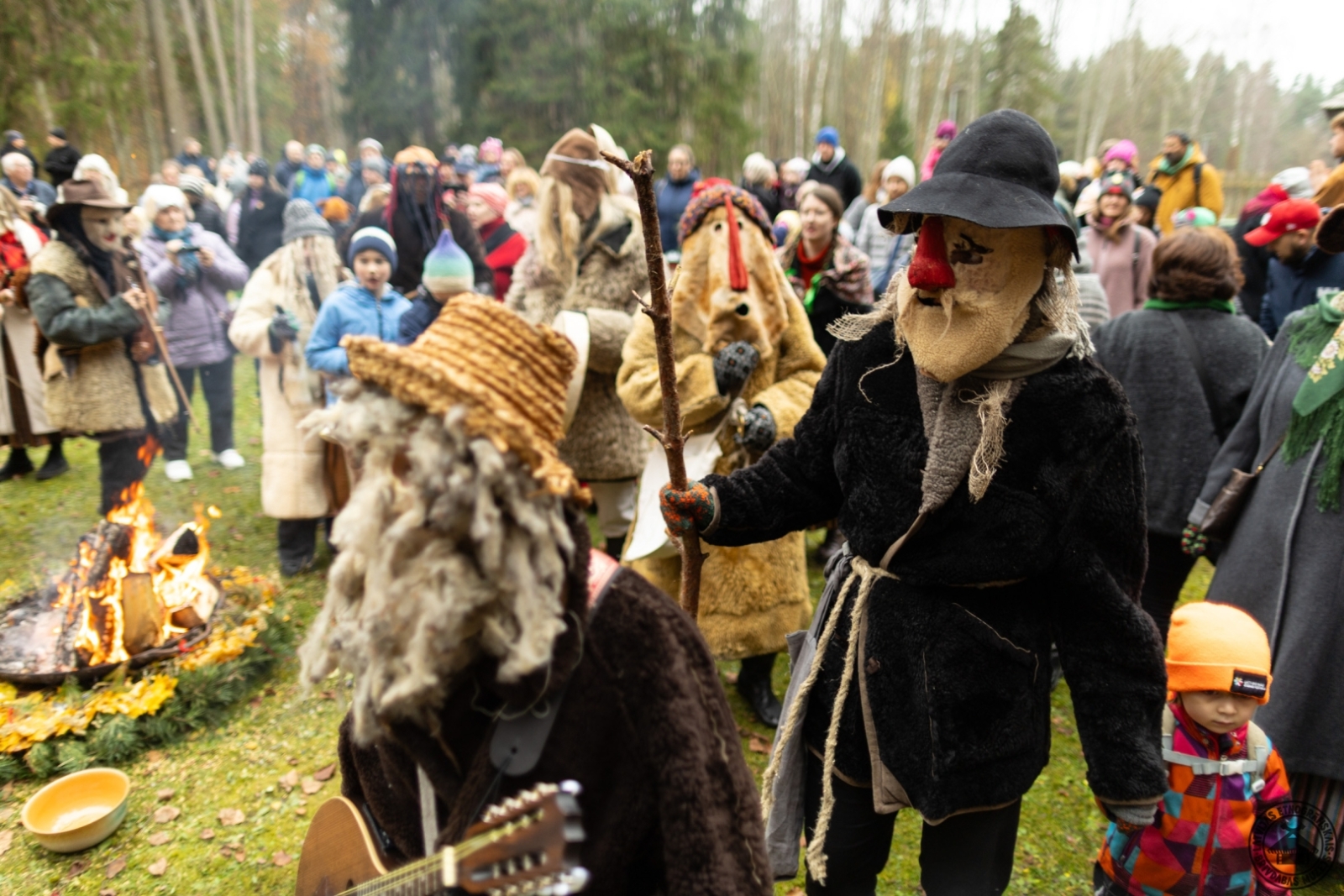 Maskas un apmeklētāji vienojas kopīgā dejā ap svētku ugunskuru. 
