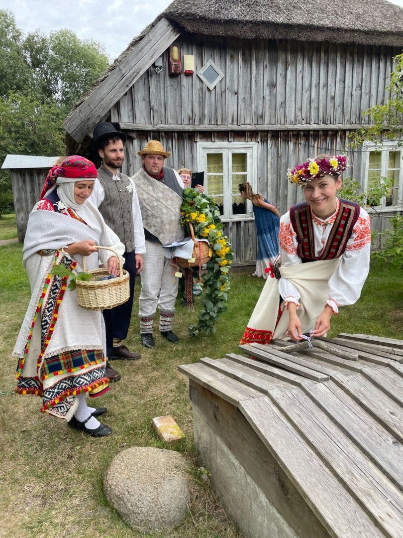 Jaunā sieva veic rituālu, ziedojot krāsainas prievītes vai dzijas sētas ūdens akai.