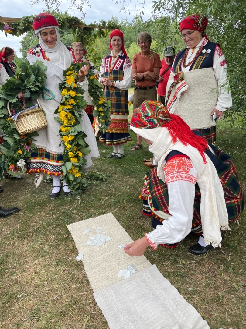 Brūtgāns nes līgavu pāri austam dvielim, kur tiek sasists šķīvis un skaitītas lauskas kāzās