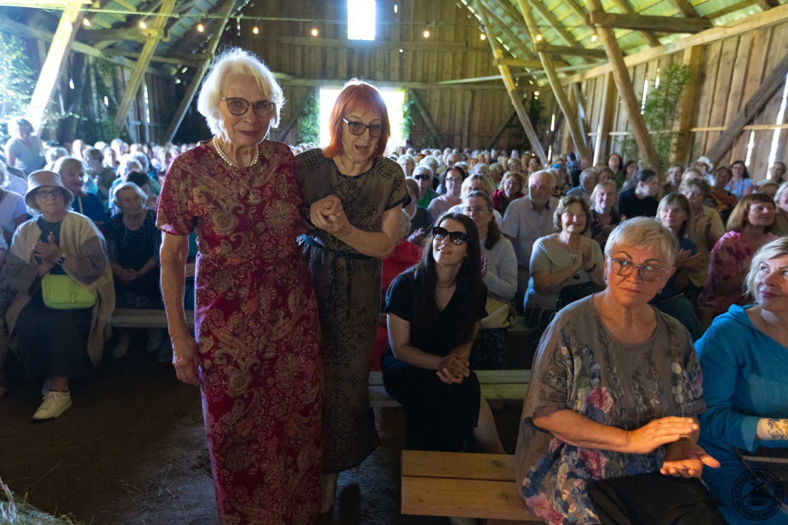Svētku brīdis: sieviete pavada cienījamu audēju saņemt muzeja goda zīmi. 
