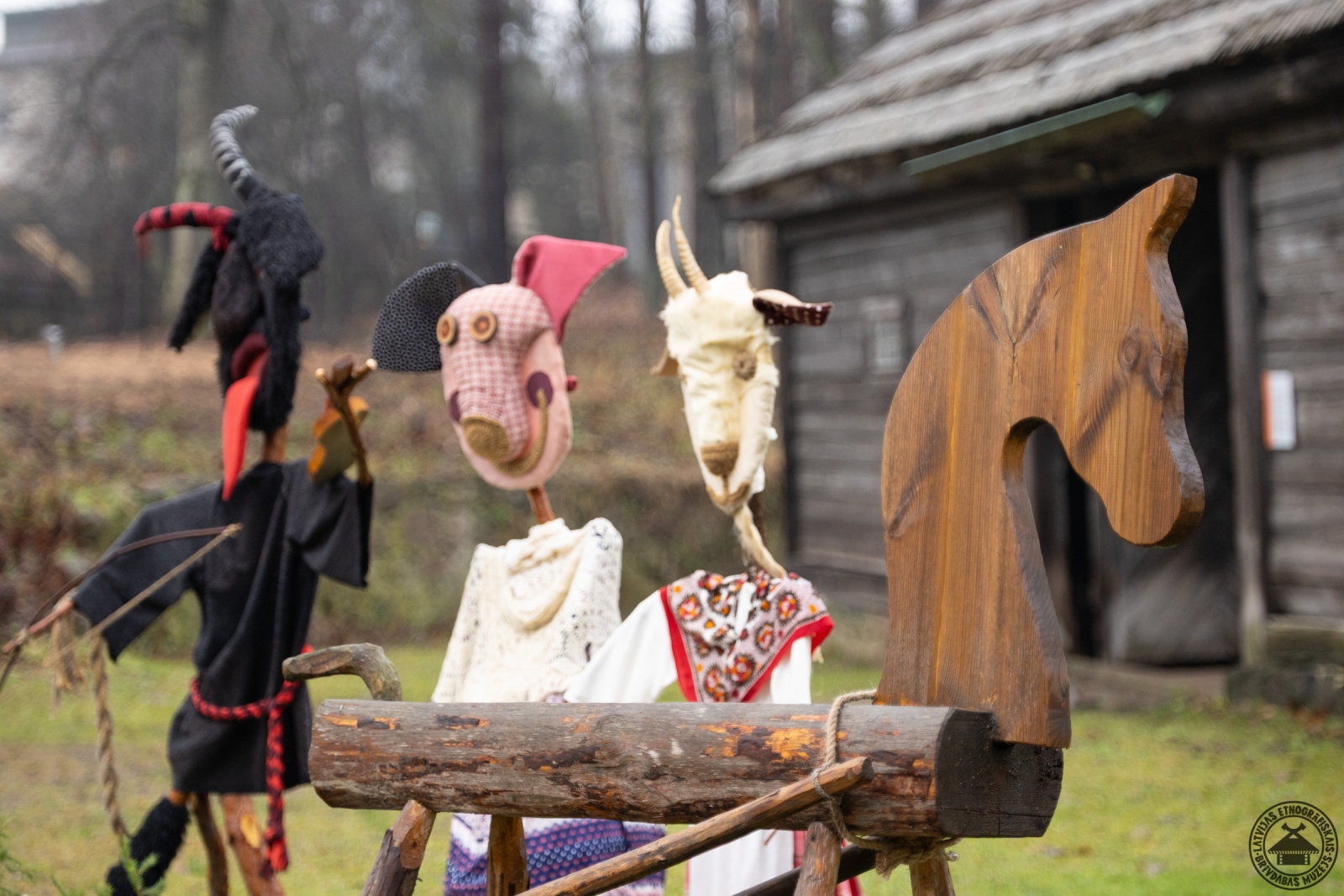 Svētku instalācija ar koka zirdziņu un dažādām Ziemassvētku maskām. 