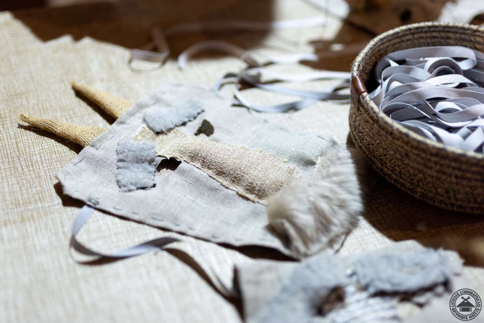 Uz galda izkārtotas tikko sašūtas tradicionālās Kazas maskas. 