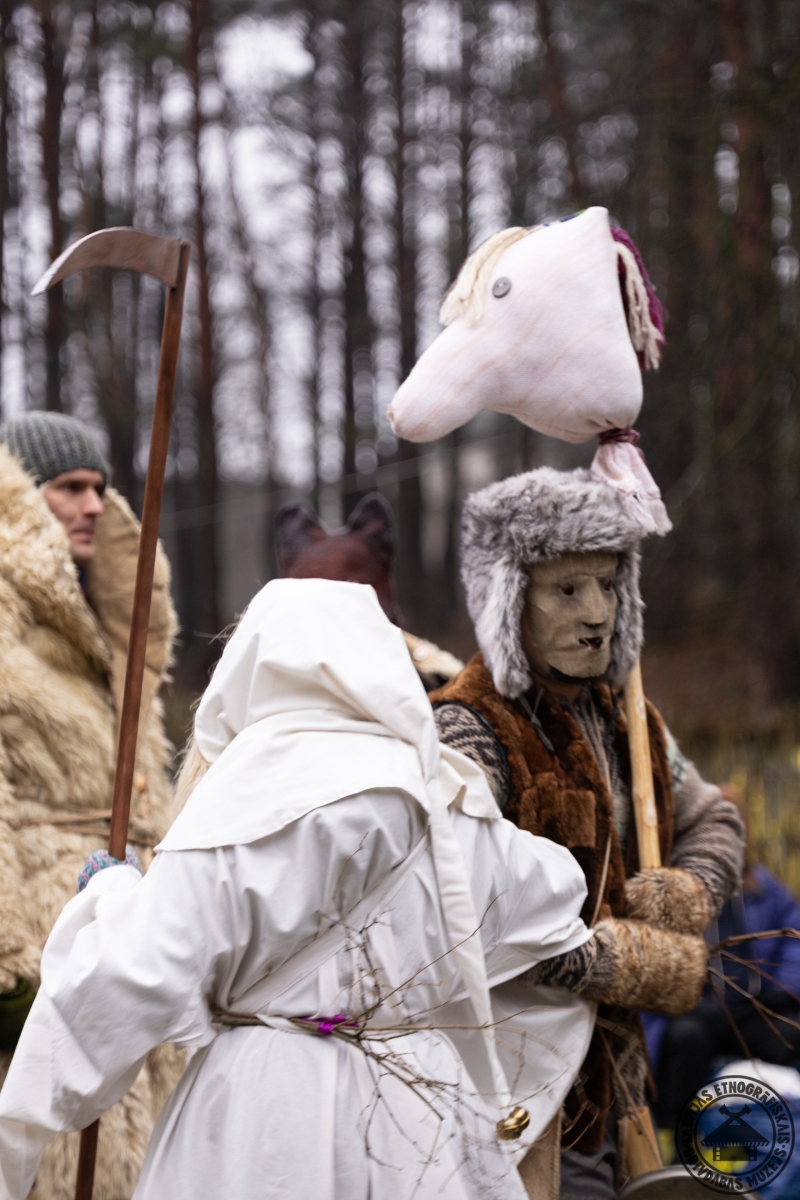 Dejas masku gājiena laikā; priekšplānā tēls Nāve ar koka izkapti. 