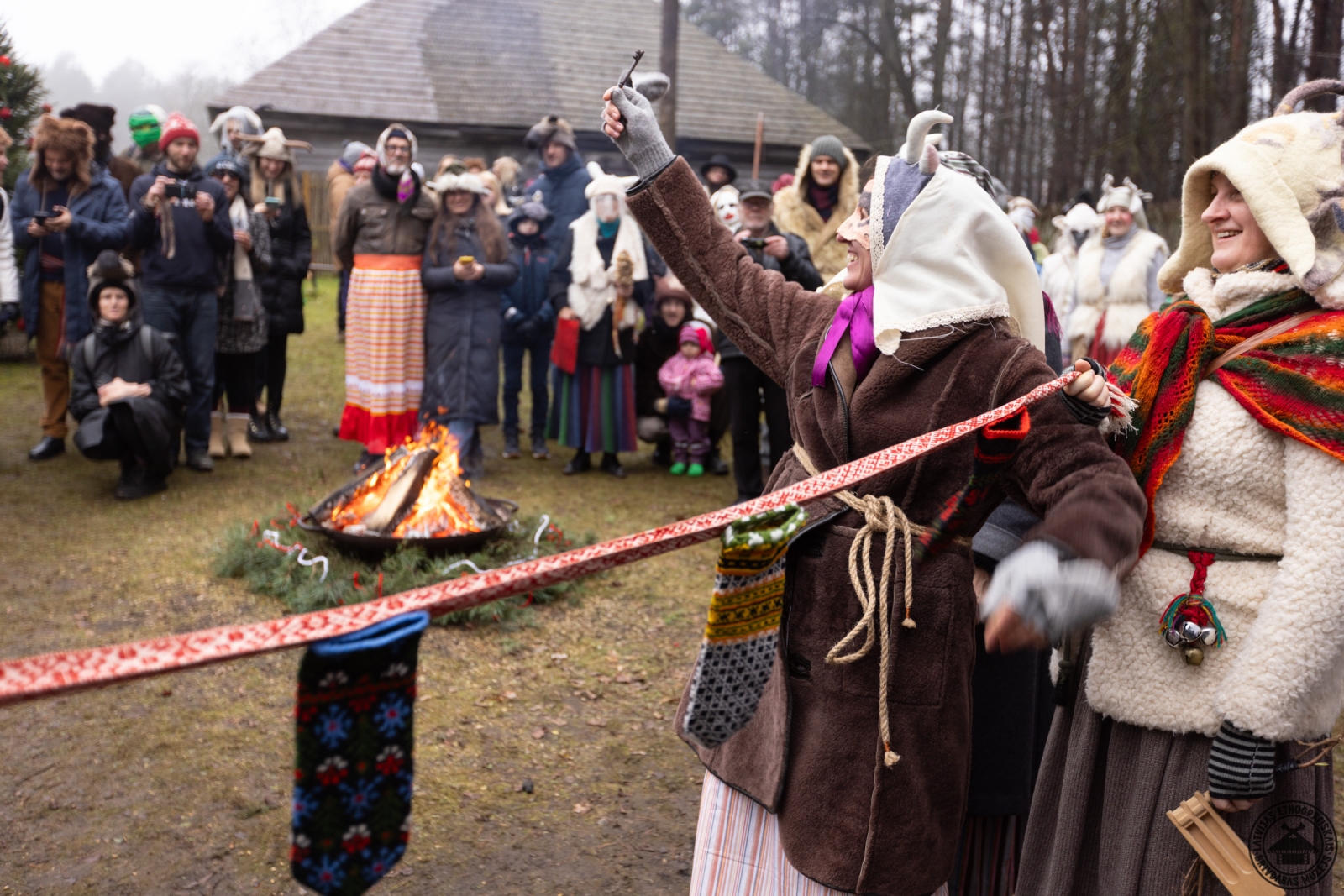 Bluķa vilkšanas rituāls; priekšplānā ozola bluķis, kas simbolizē pērnā gada grūtības. 