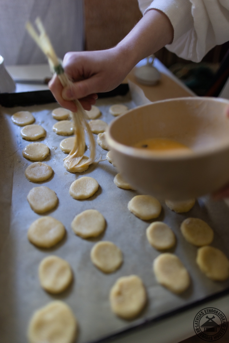 Tuvplāns: cepumu apsmērēšana ar olu, izmantojot tradicionālo spalvu otiņu. 