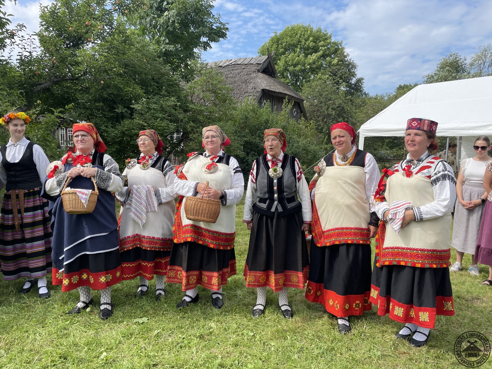 Nīcas etnogrāfiskais ansamblis krāšņos tērpos ar koši oranžajām apakšmalām apdzied kāziniekus. 