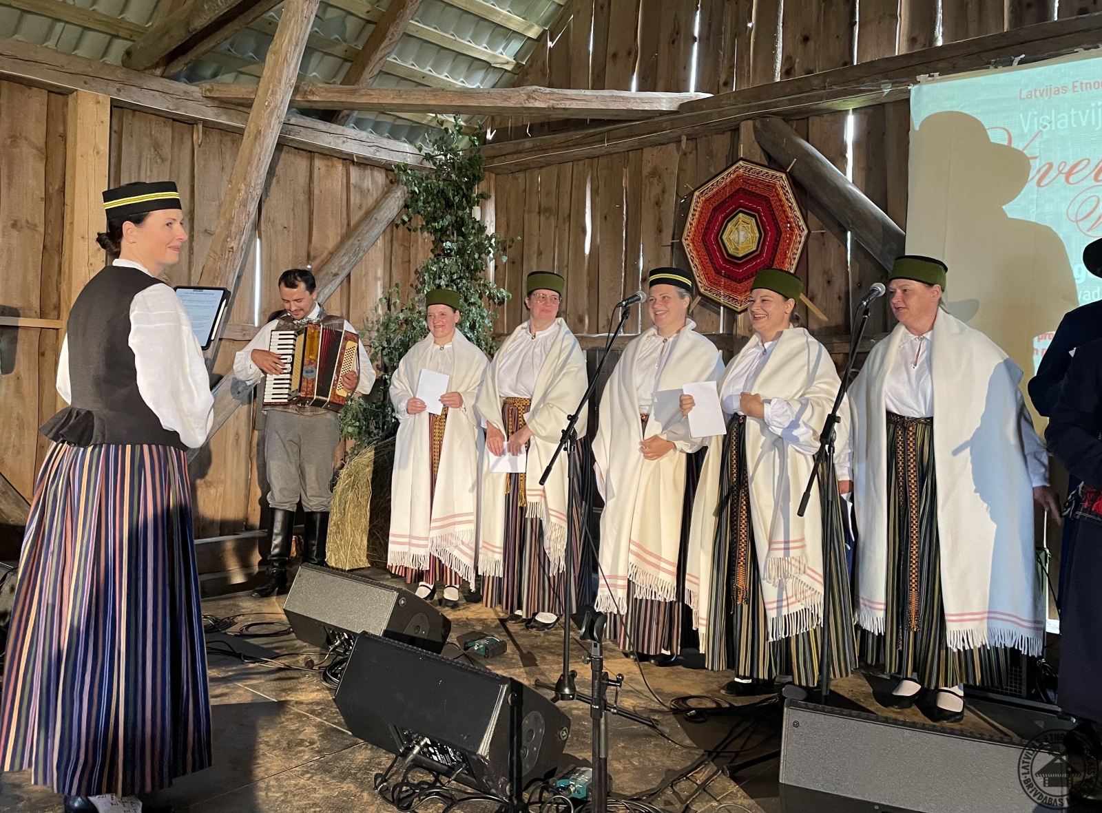 Piebalgas kora grupa sniedz muzikālu priekšnesumu Vēveru šķūnī. 