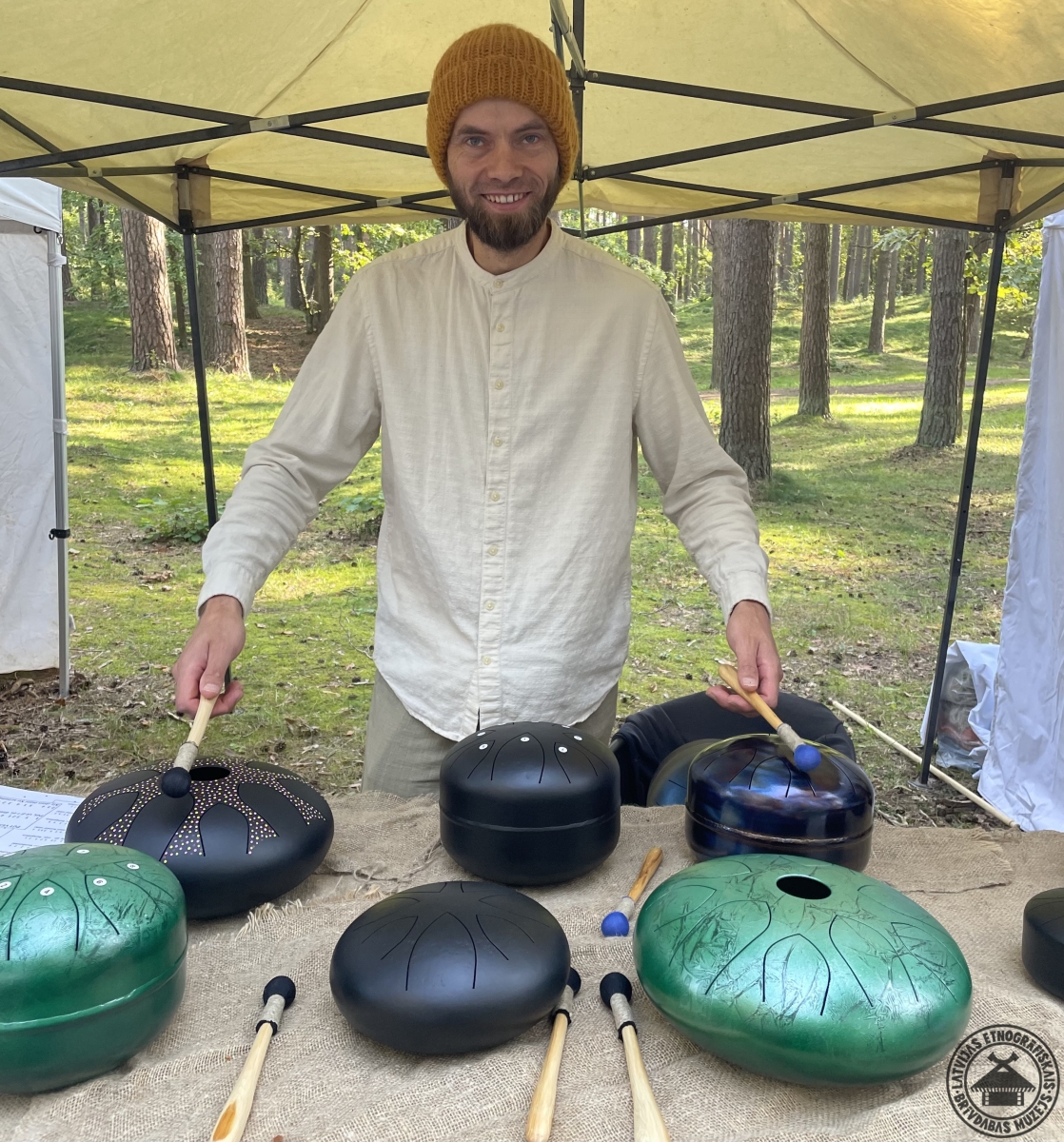 Mūzikas instrumentu meistars rāda paša gatavotās kokles un citus koka instrumentus. 