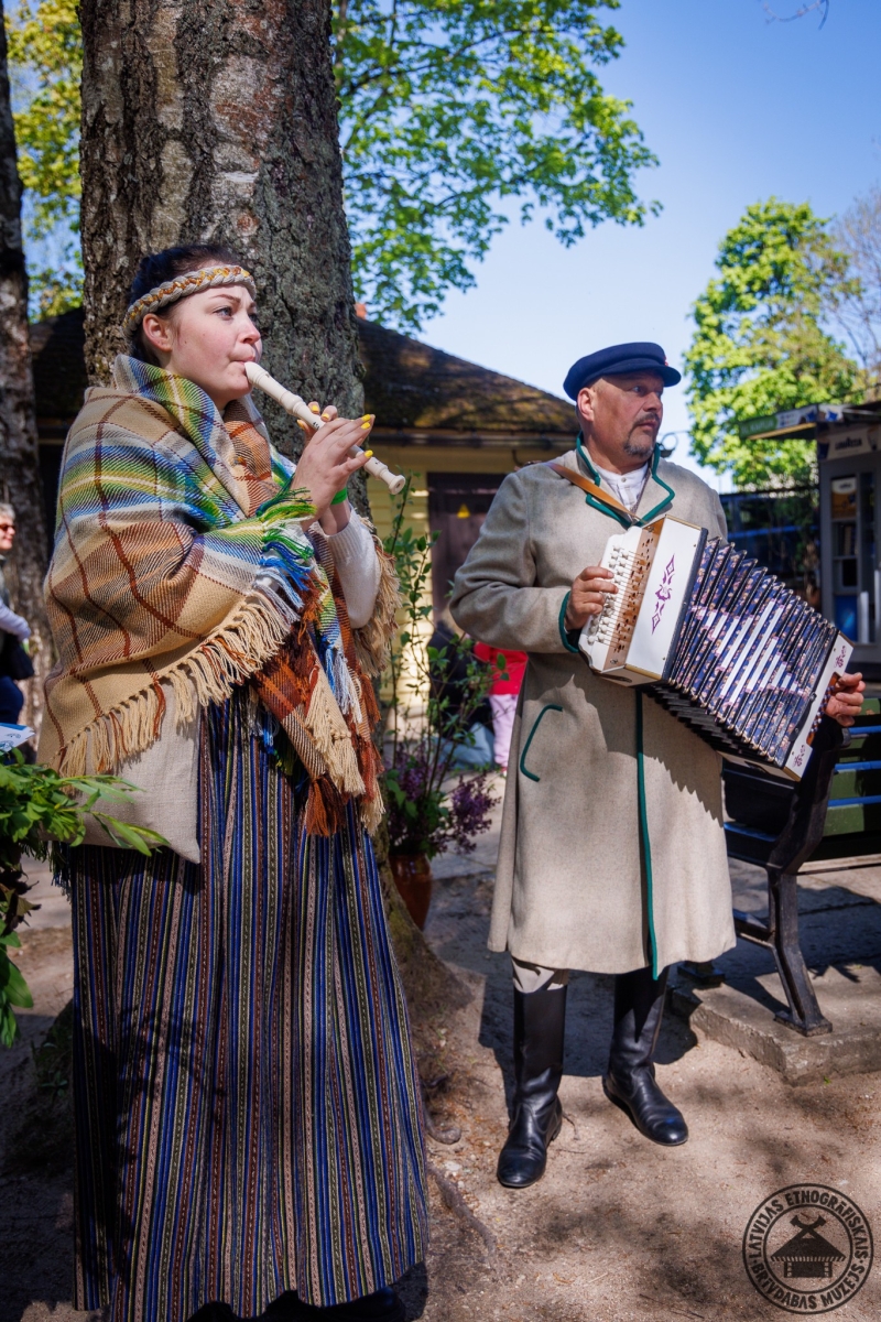 Muzikāls priekšnesums atklāšanā: meitene spēlē stabuli, blakus kungs ar akordeonu. 