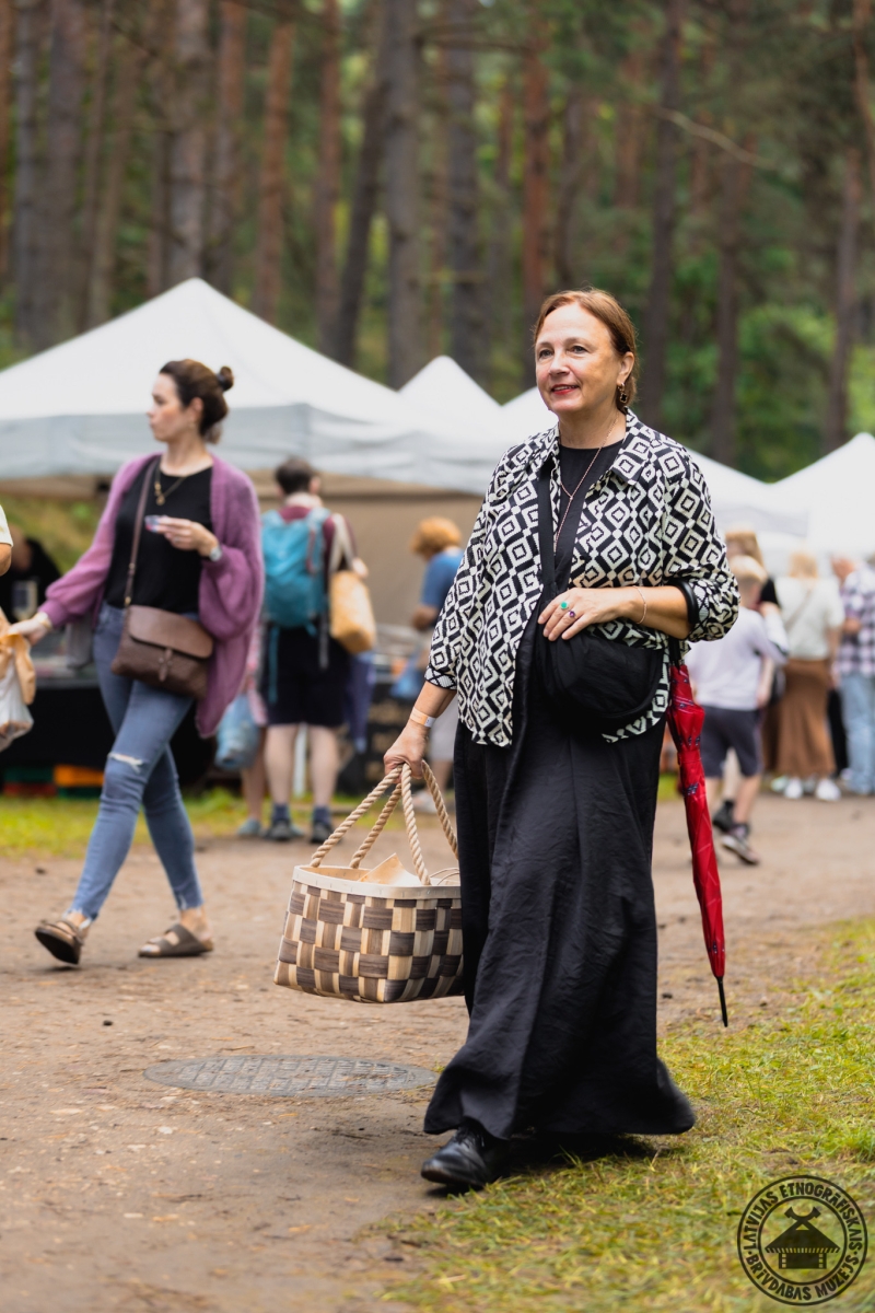 Apmeklētāja ar lielu, tradicionālu skalu grozu iepirkumiem. 