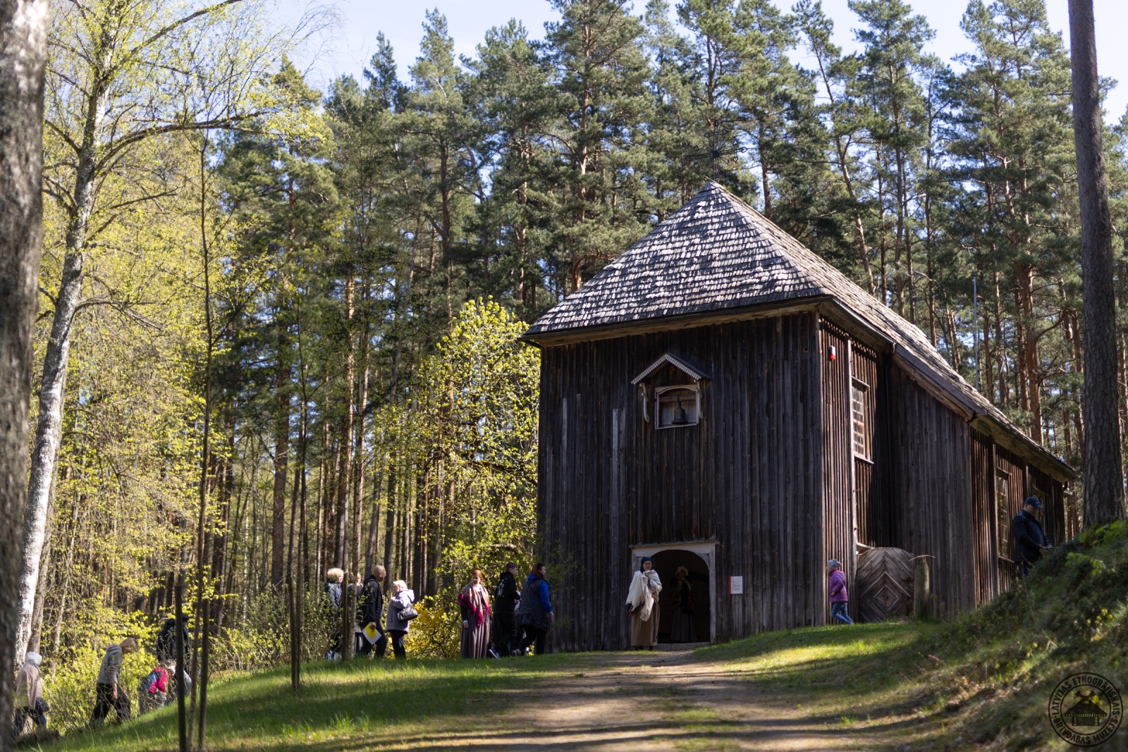 Apmeklētāju pulcēšanās pie vēsturiskās Bornes koka baznīcas durvīm. 