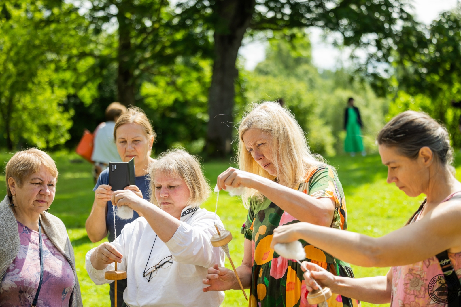 Apmeklētājs izmēģina seno dzīparu šķetināšanas prasmi, izmantojot koka vārpstiņu. 