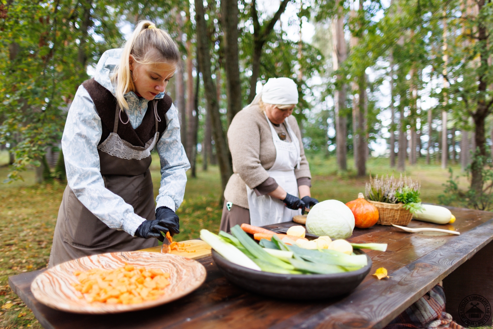 Saimnieces pie liela galda čakli smalcina dārzeņus tradicionālajai rudens ražas zupai. 