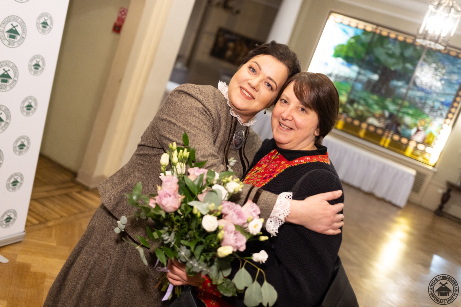 Rucavas pārstāve tradicionālajā tērpā pasniedz īpašu sveicienu muzeja vadībai. 