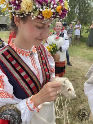 Kāzu tradīcija: jaunā līgava demonstrē savu prasmi, mēģinot salāpīt cauru vilnas zeķi. 