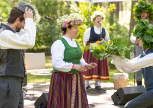 Muzeja direktorei svētkos pasniedz ziedu pušķi un tradicionālu Jāņu vainagu