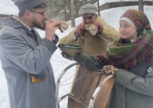 Jaunieši pie ragaviņām; puiši demonstrē tradicionālo mielastu – cūkas ausis