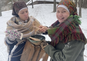 Divas priecīgas meitenes ar bļodu, kurā ir vārīta cūkas gaļa un ausis