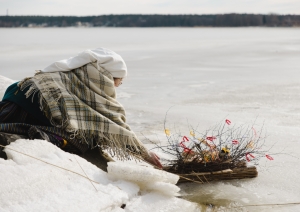 Meitene tautastērpā veic rituālu, peldinot ūdenī ziedojumu Jūras mātei