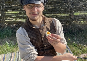 Puisis apsēdies zaļā zālītē un bauda svētku mielastu, ēdot vārītu olu, kas ir tradicionāls Ūsiņu dienas ēdiens