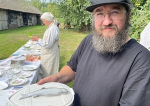 Vīrietis rokās tur un rāda īpašu, māla vai porcelāna antīko zupas terīni