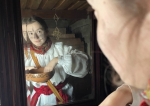 Meitene pie spoguļa smērē seju ar oglēm, lai maskotos un paliktu neatpazīstama ķekatās.