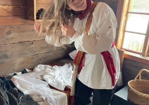 Meitene turpina pārģērbšanās procesu, pielāgojot puiša apģērbu Katrīndienas maskai.